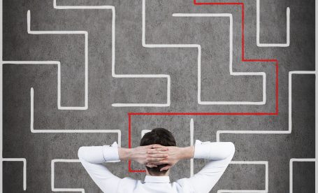 businessman sitting and looking to out of the maze